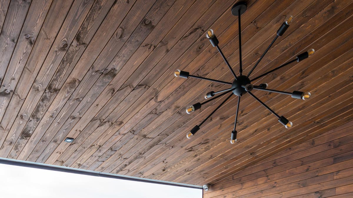 industrial chandelier hanging from wooden ceiling